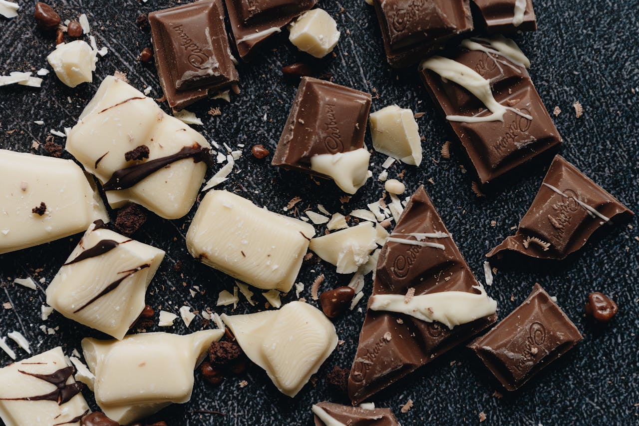 Close-up of assorted milk and white chocolate pieces with artistic drizzle.